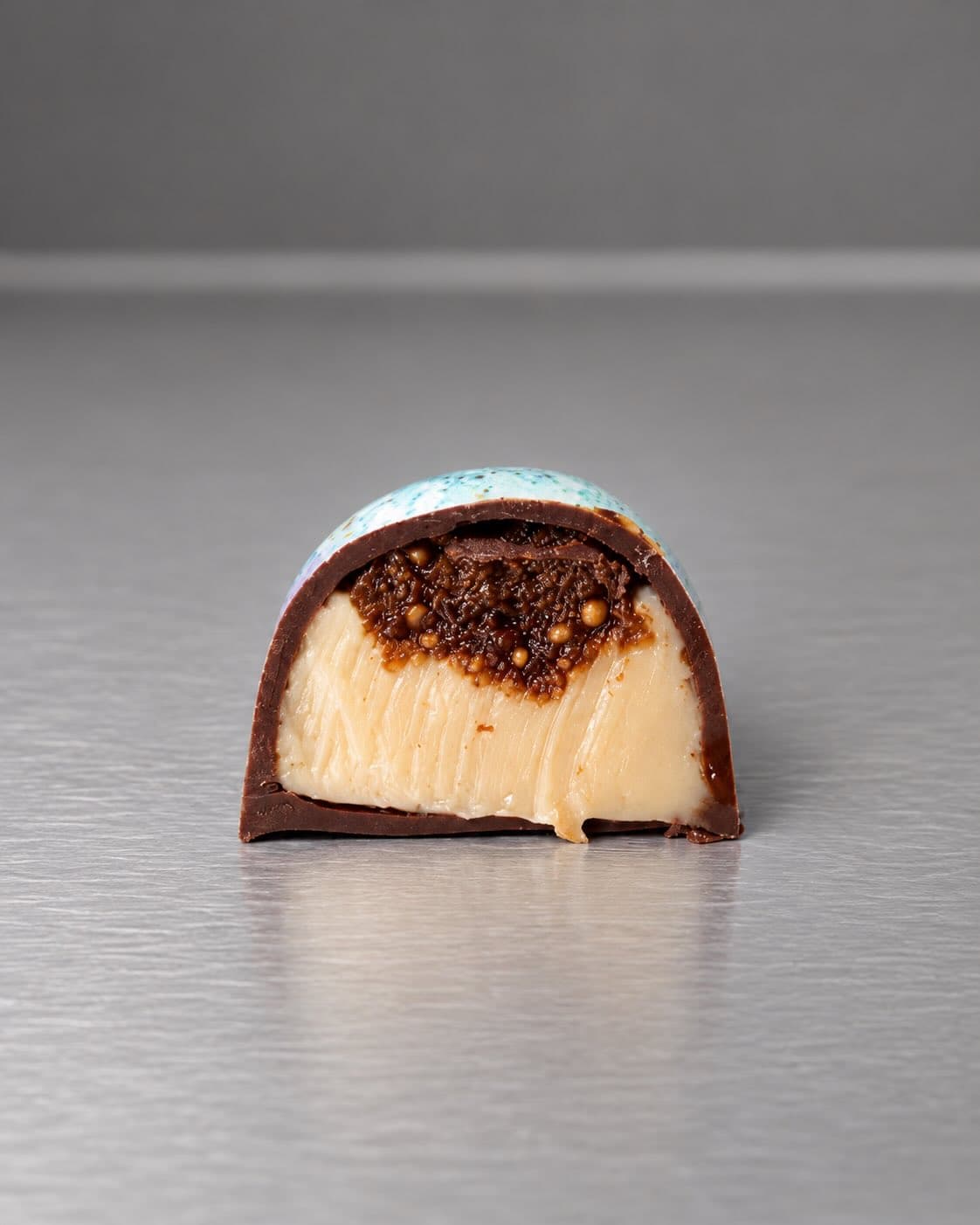 Dome bonbon cut in half with a crunchy layer